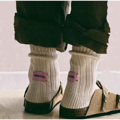 Woman wearing white cotton socks and apricot Bali Clogs, showcasing a stylish and comfortable casual look